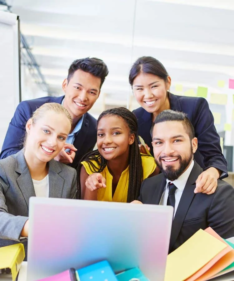 Grupo de empreendedores reunido em torno de um notebook para organizar um negócio