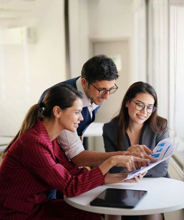 Profissionais analisando gráficos e documentos em uma reunião de consultoria