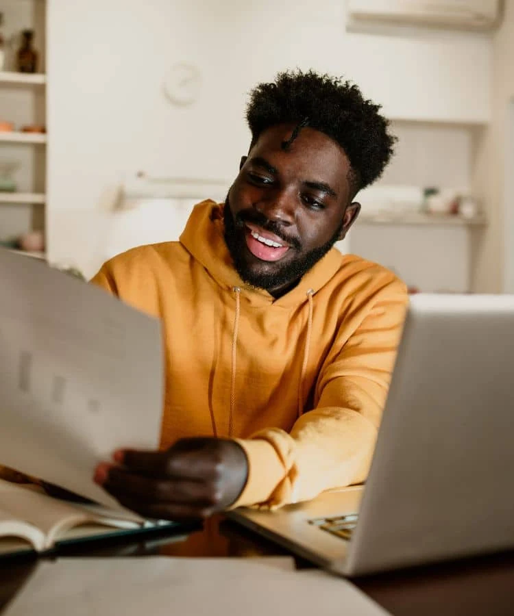 Pequeno empresário revisando documentos ao lado de um notebook
